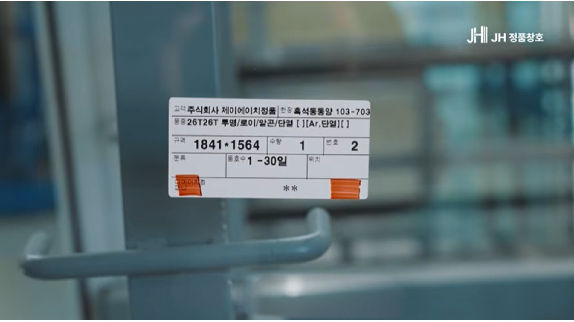 유리에 붙은 사양 라벨 — 26T, 로이, 아르곤, 단열 간봉과 규격·현장명이 적혀 있다